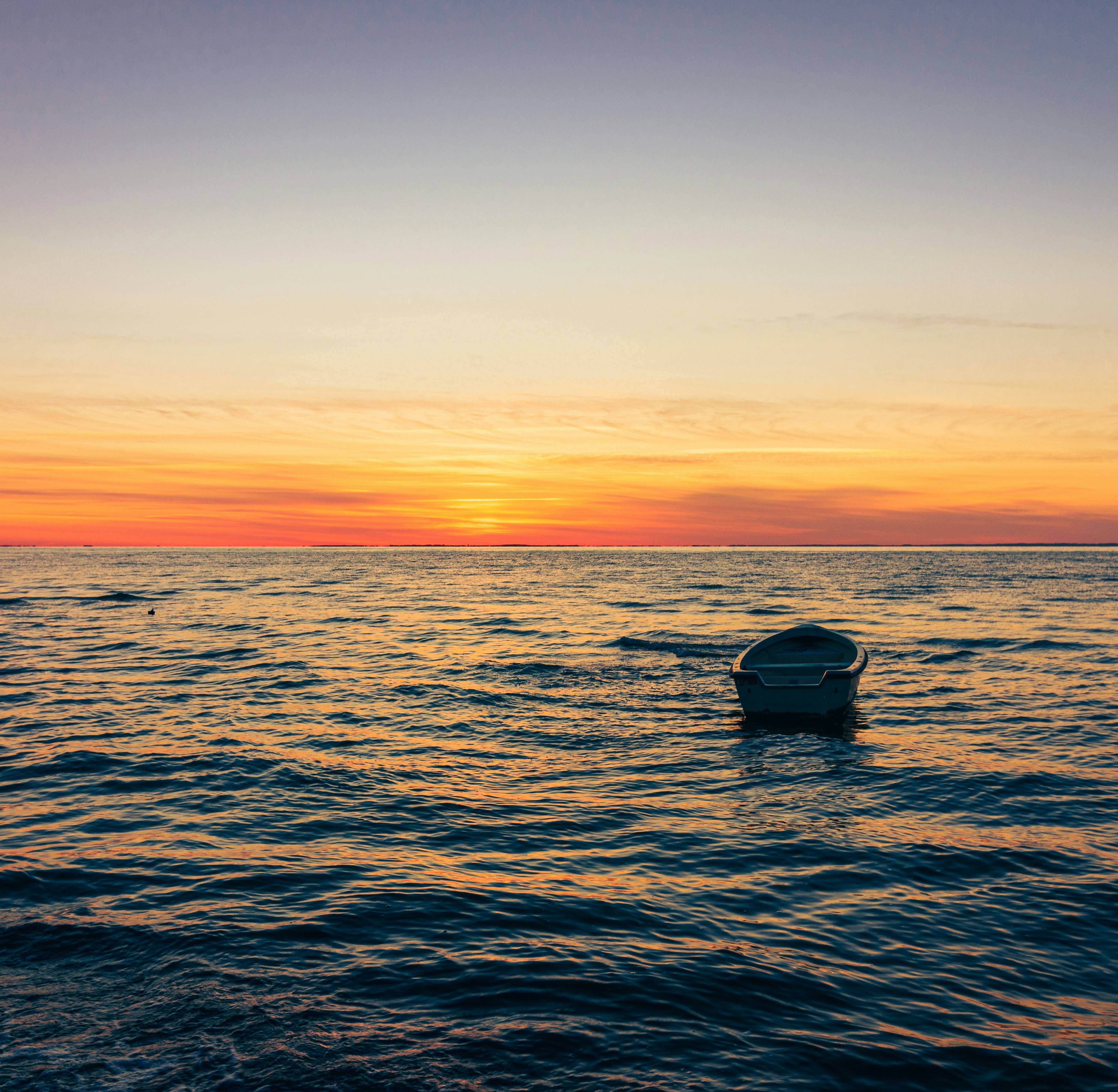 Boot schippert auf dem Meer bei Sonnenuntergang